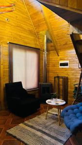 un soggiorno con un divano e un tavolo di Cabañas Alpinas Alessandro a Recinto