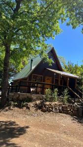 una baita di tronchi con tetto verde di Cabañas Alpinas Alessandro a Recinto