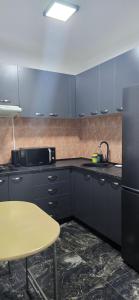 a kitchen with blue cabinets and a table and a sink at EVA Studio Eforie Nord in Eforie Nord