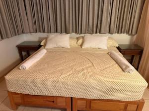 a bed with two pillows on it in front of a window at Departamento paraíso in Lo de Marcos