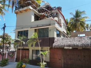 a white house with a fence and palm trees at Departamento paraíso in Lo de Marcos +4 photos