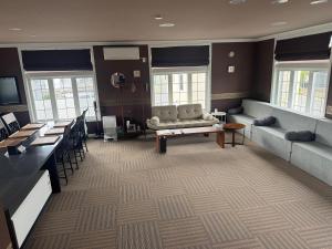 美瑛町Biei Terrace 2F 専用玄関 127平米 85型スマートTV -駅前通り&景観条例地区-的一间配有沙发、桌子和窗户的等候室
