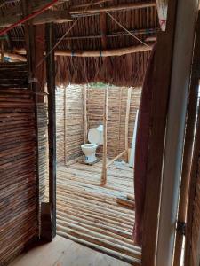 a bathroom with a toilet in a straw house at Private Traditional Hut on the water with 2 rooms in Wichubualá