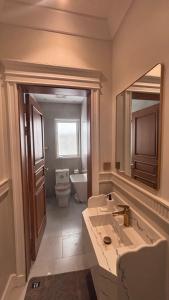 Un baño con lavabo, inodoro y espejo. en Modern studio, en Yeda