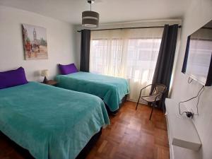 a bedroom with two beds and a window at El Retorno a Viña in Viña del Mar