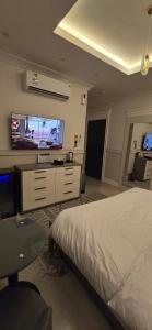 Un dormitorio con una cama y un televisor de pantalla plana. en Modern studio, en Yeda