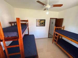 a room with three bunk beds and a ceiling fan at Casa bem espaçosa com piscina, campo de futebol e área gourmet a um quarteirão da lagoa de Praia Seca in Araruama +44 photos