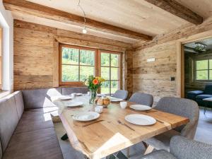 Un comedor con mesa y sillas de madera. en Heualm, en Hopfgarten im Brixental