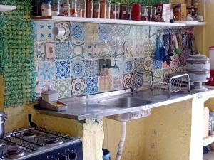 a kitchen with a sink and a stove at Hostel One Love Lençois in Lençóis
