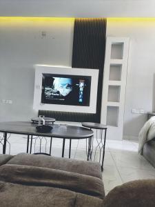 a living room with a table and a flat screen tv at Cozy studio in vibrant Riyadh in Riyadh