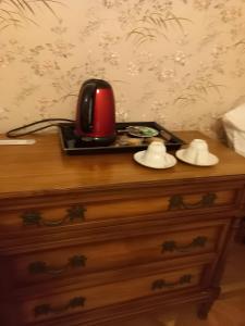a red telephone on a black tray on a dresser at Les Hortensias Entre Terre Et Mer in Plogoff