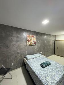 - une chambre avec un lit et un mur gris dans l'établissement Apto moderno próximo à COP30 e pontos turísticos, à Belém