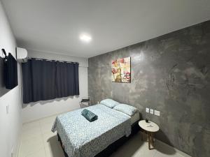 a small bedroom with a bed and a table at Apto moderno COP30 com Área de Lazer e Estacionamento in Belém