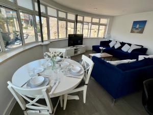 a living room with a white table and a blue couch at Bournemouth Nest in Bournemouth