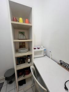 a room with a table and a shelf with dishes at Manaira Suite 02 in João Pessoa