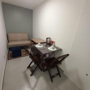 巴西利亚Apartamento 1 quarto Asa Norte prédio misto - residencial comercial - wi-Fi - 1 a 3 hospedes - sem taxas的一张桌子和椅子,位于一个配有沙发的房间