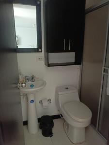 a small bathroom with a toilet and a sink at Apartamentos para Turismo cerca a Parques Tematicos in Montenegro