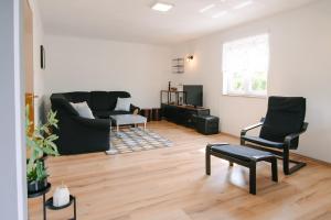a living room with a black couch and chairs at Holiday house with a parking space Grabovac, Plitvice - 21998 in Rakovica