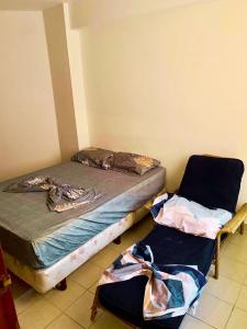 a bedroom with two beds and two chairs at Arena, Mar y Amaneceres para Siete frente a Farmatodo tucacas in Tucacas +9 photos