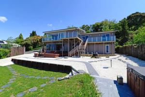 a house with blue windows and a yard at Rotorua Luxury lakeside Resort in Rotorua