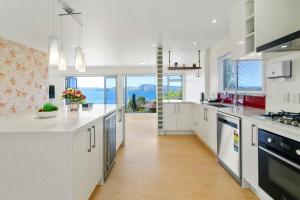 a large kitchen with white counters and a large window at Rotorua Luxury lakeside Resort in Rotorua