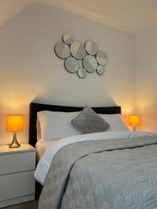 a bedroom with a bed with two lamps and a clock at Modern Stay - Walk to Everything 6 in Ipswich