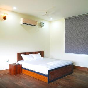 a bedroom with a bed in a room at Rocopie Farm in Rohtak