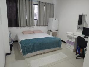 a bedroom with a bed and a desk and a computer at Elizondo Pousada Eneias Pinheiro in Belém