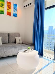 a living room with a couch and a table at The Sun Executive Suite - Dolphin's Home in Bayan Lepas