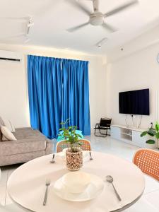 a living room with a table and a blue curtain at The Sun Executive Suite - Dolphin's Home in Bayan Lepas +45 photos
