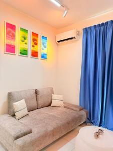 a living room with a couch and blue curtains at The Sun Executive Suite - Dolphin's Home in Bayan Lepas