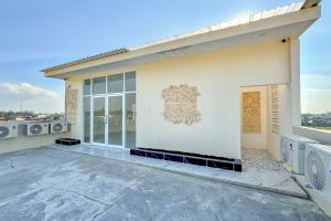 a white building with a large window on it at Urbanview Olive Near Graha Saba Buana Surakarta in Bonorejo