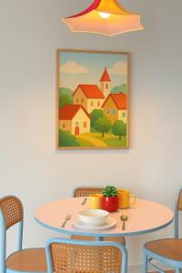 a table and chairs with a painting on the wall at The Sun Executive Suite - Dolphin's Home in Bayan Lepas