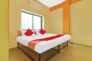 um quarto com uma cama com almofadas vermelhas e uma janela em Hotel O Golden Key em Nagpur mais 17 fotografias