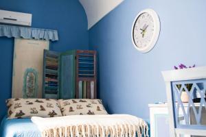 um quarto com paredes azuis e um relógio na parede em B&B Via Roma em San Severo