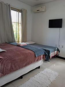 a bedroom with a bed and a television in a room at Elizondo Pousada Eneias Pinheiro in Belém