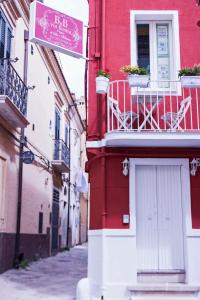 um edifício vermelho com uma varanda e um sinal nele em B&B Via Roma em San Severo