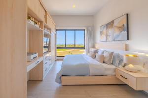 Un dormitorio con una cama grande y una ventana grande. en New! Luxury PH with Pool Golf & Ocean Views, en Punta Cana 62 fotos más