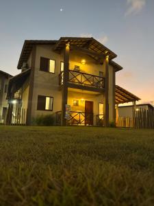 a house with a sunset in the background at Chalé Paraíso Santo Amaro in Santo Amaro