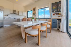 Una cocina con una mesa y sillas en una cocina. en New! Luxury PH with Pool Golf & Ocean Views, en Punta Cana