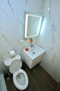 a bathroom with a white toilet and a sink at Casa Rural El Paraíso de Saona in Mano Juan