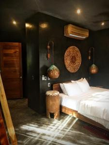 a bedroom with a white bed and a wooden stool at Casa Vive Bacalar in Bacalar
