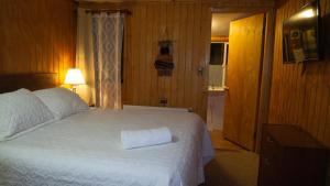 a bedroom with a bed with a towel on it at Hostal Lejana Patagonia in Cochrane +6 photos