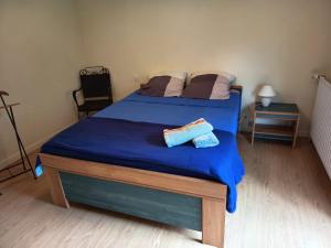 a bedroom with a blue bed with two towels on it at Maison de vacances en Ardèche in Pailharès