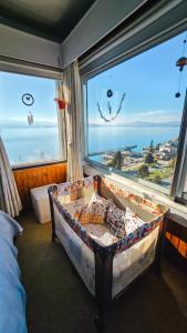 a bedroom with a crib in front of a large window at Giraluna Center depto con vista al lago en Bariloche in San Carlos de Bariloche +32 photos