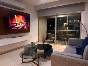 a living room with a tv and a couch and a table at Vía Montejo, Mérida Yucatán in Mérida