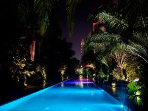 a large swimming pool with palm trees at night at Vía Montejo, Mérida Yucatán in Mérida