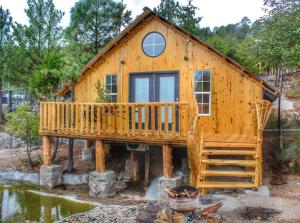 a log cabin with a large porch and a deck at Black Birds Cabins Creel in Creel