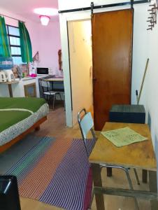 a room with a bed and a table and a door at Departamento MGS in Valle Hermoso +11 photos
