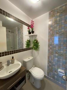 a bathroom with a toilet and a sink and a mirror at Ocean Blue, Vista Frontal Al Mar in Lima